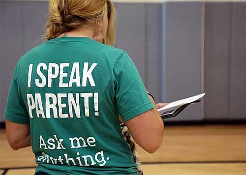 Woman wearing a shirt that says I speak parent, ask me anything.
