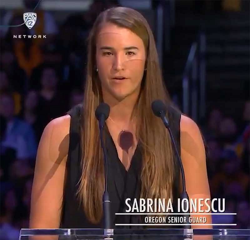 Sabrina Ionescu speaking at a podium in the Staples Center