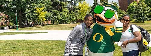 A mother and son posing with the Oregon Duck