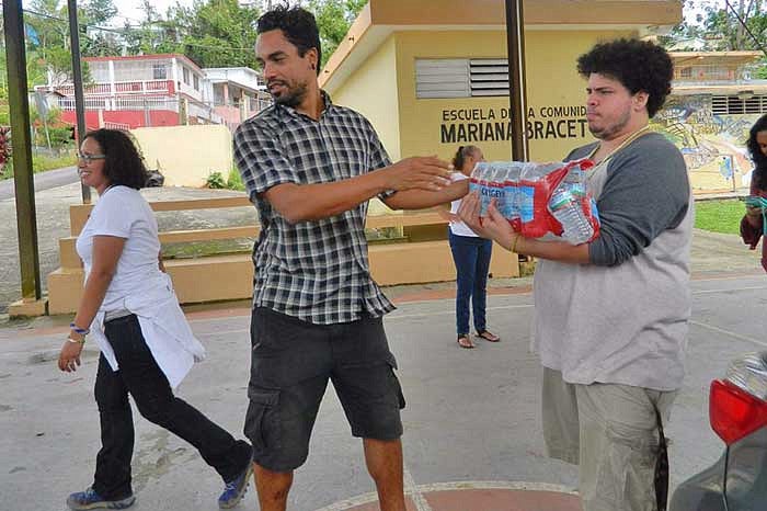 Students passing cases of water