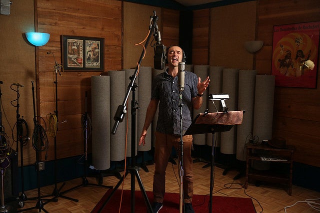 Steve Perry in the recording studio singing at a microphone