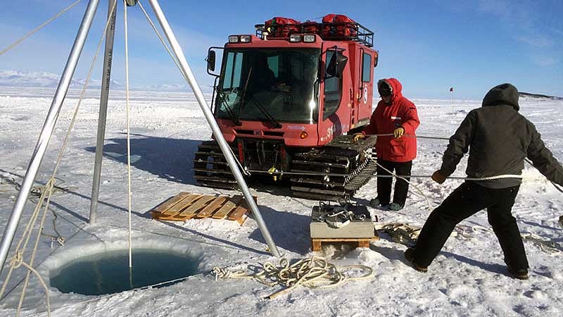 Lowering concrete anchor blocks through a hole in 8ft thick ice