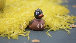 Toy duck with O next to yellow pompom streamers