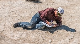 UO professor Greg Retallack measures a mammoth footprint