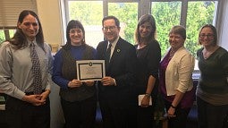 President Michael Schill presents the Green Resilient Office certificate to the Department of Sociology.