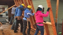 Students in the OregonBILDS studio frame and lift exterior walls into place.