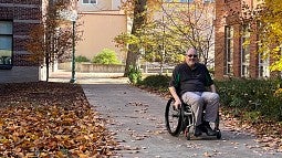 John Miller navigating campus in wheelchair