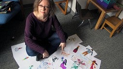 Marjorie Taylor sits amid creative drawings done by 8- to 10-year-old children