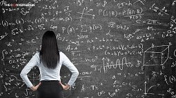 Woman looking a chalkboard with math equations