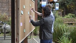 Museum exhibitions staff members prep the corkboard