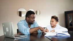 Stock image of man and child working on school