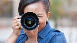 Polly Irungu looking through a camera lens