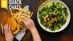 Burger and fries next to bowl of salad