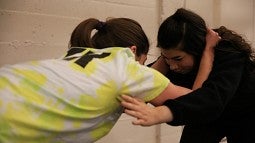 Two students practice in a women's self-defense class.