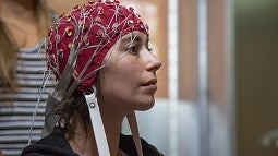 Image shows a subject wearing cap covered in electrodes