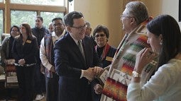 UO President Michael Schill shakes hands with Don Gentry, chairman of the Klamath Tribal Council at the Many Nations Longhouse