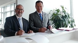Dennis Galvan (left) signing agreement with his Russian counterpart.