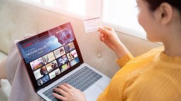 Woman selecting video on laptop