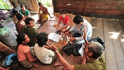 A doctor making a home visit in a rural area of Laos.