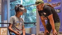 Danny Pementel helps youngster with VR headset