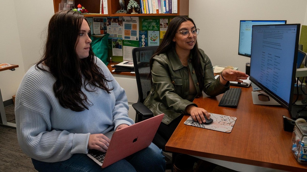 A student and advisor work at a computer
