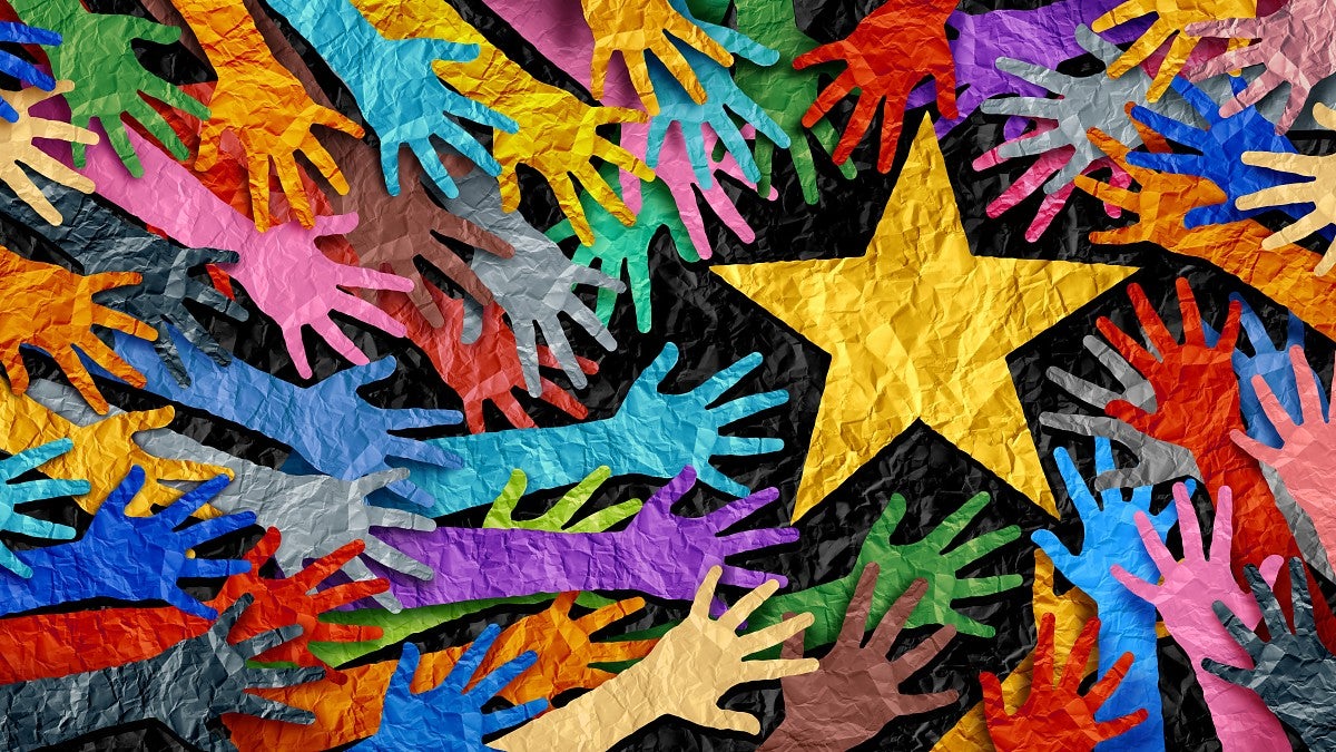 multi colored paper cutouts of arms with hands reaching for a gold star