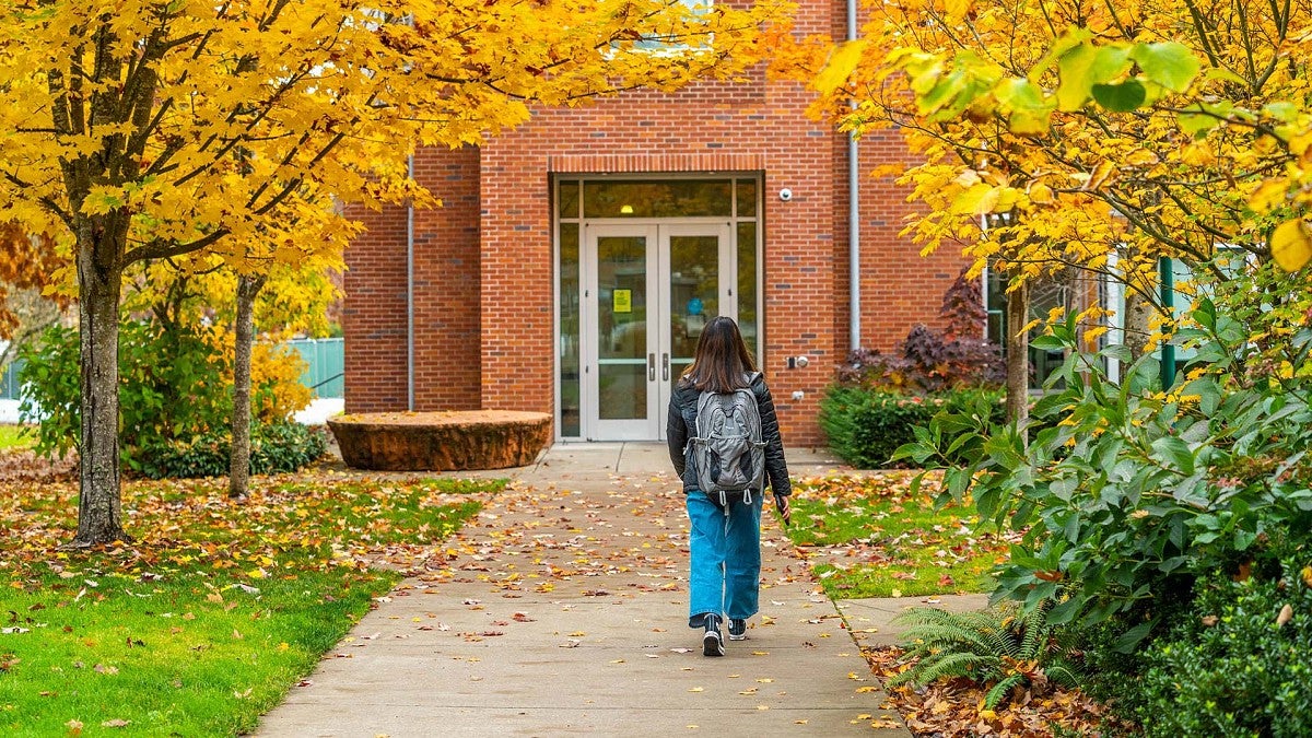 Student walking on campus in fall