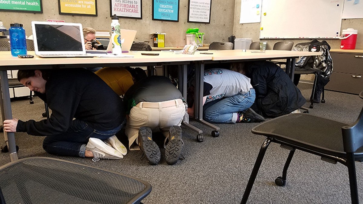 People crouching under desks
