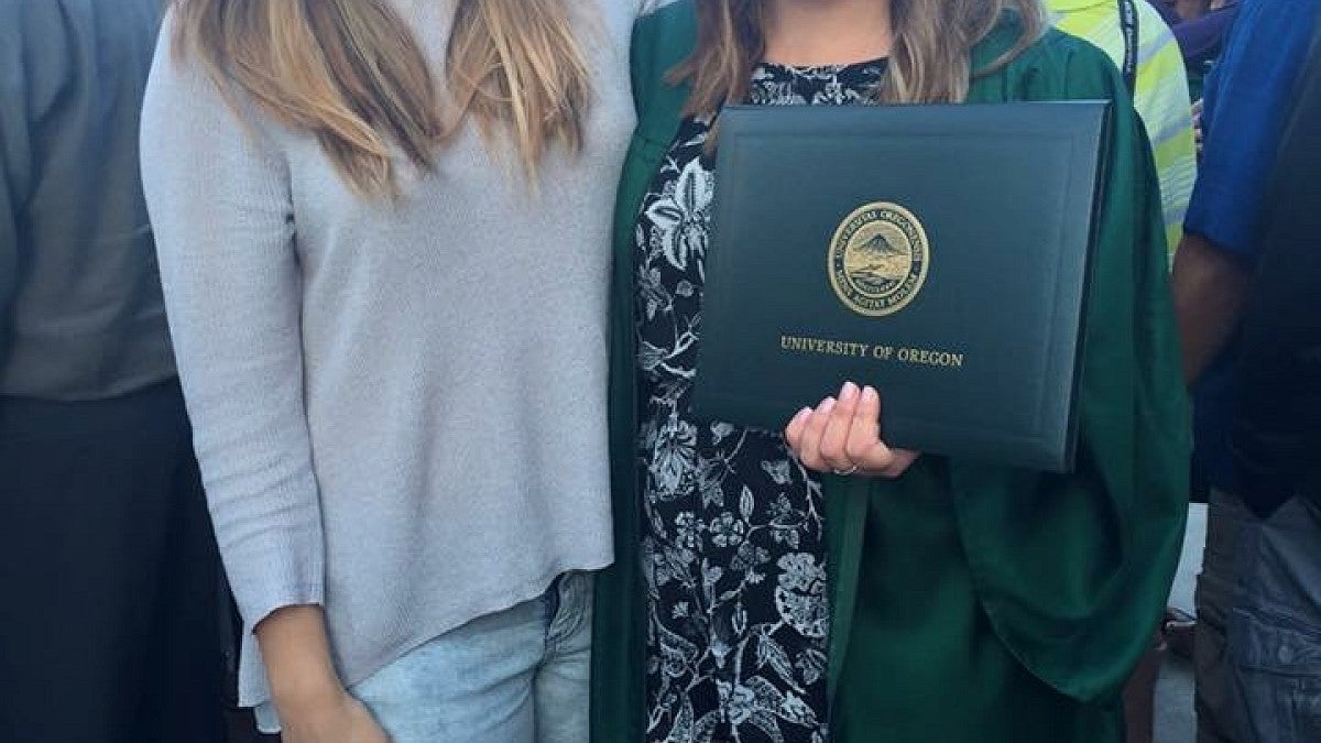 UO graduate Sarah Oller (right) and her friend Yuki Partridge at commencement