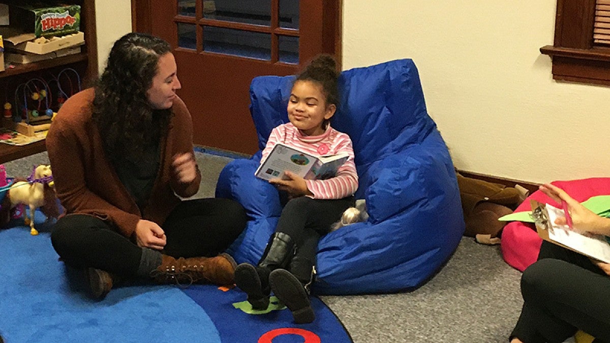 UO doctoral student Lindsay Gulgatch works with young girl