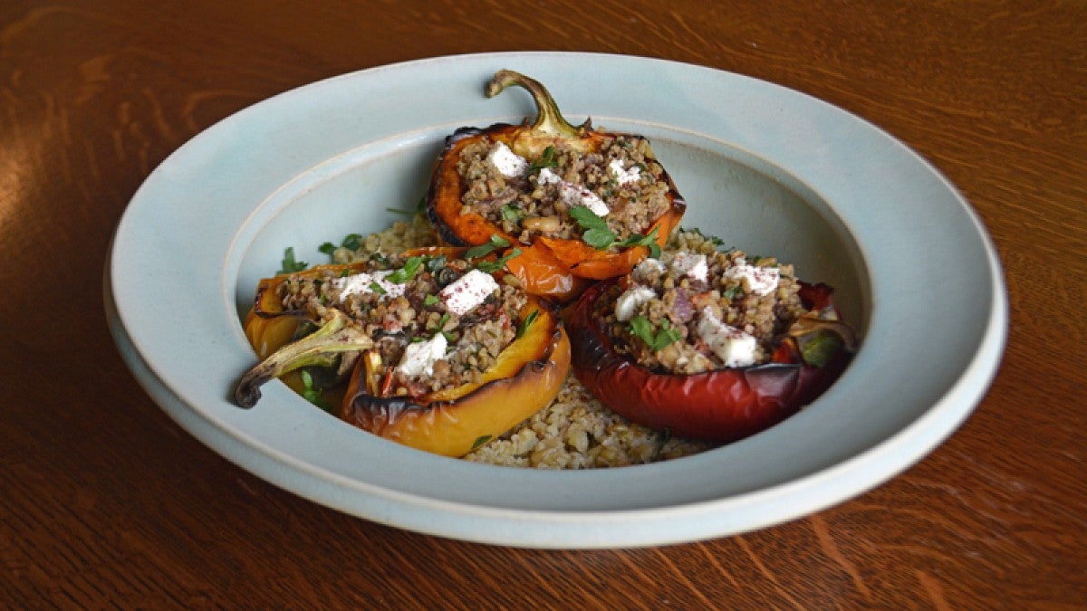Bowl filled with roasted peppers with freekeh and goat cheese