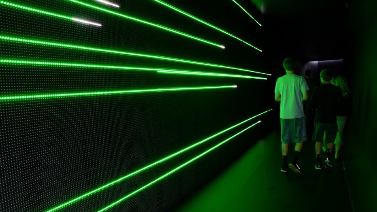 Students next to green neon lights