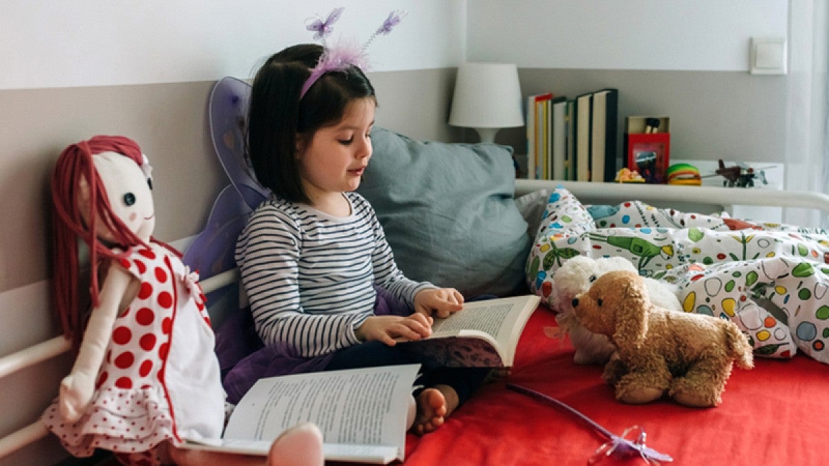 Child reading to stuffed animals