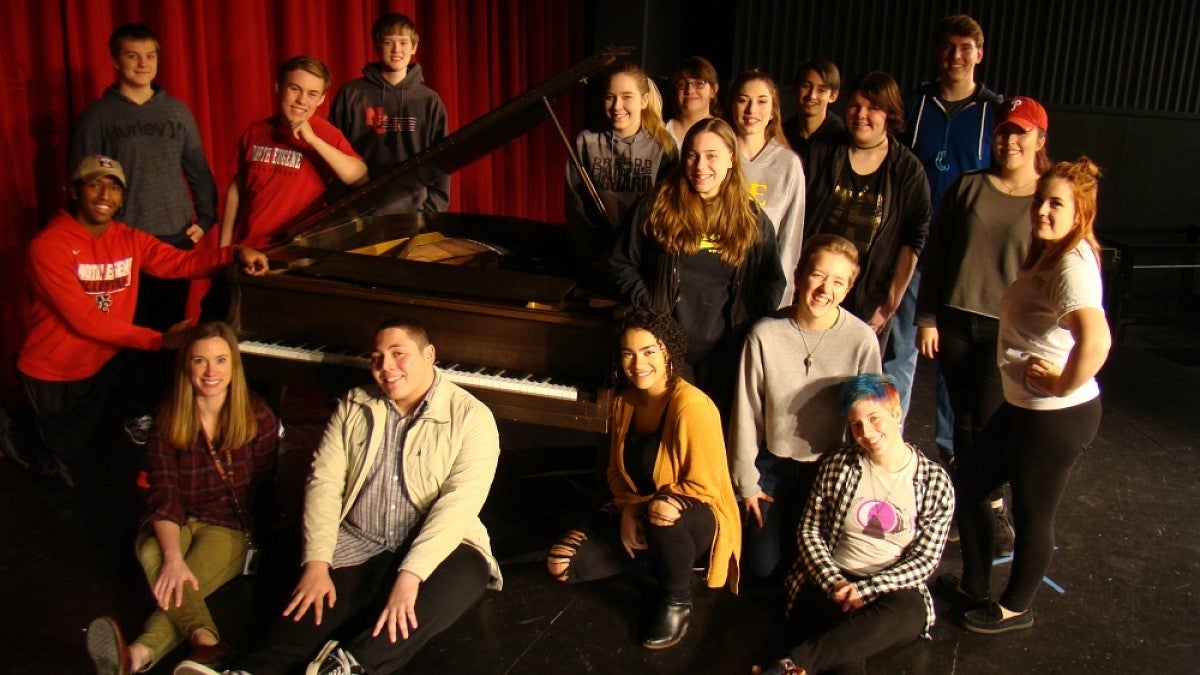Choir students around piano