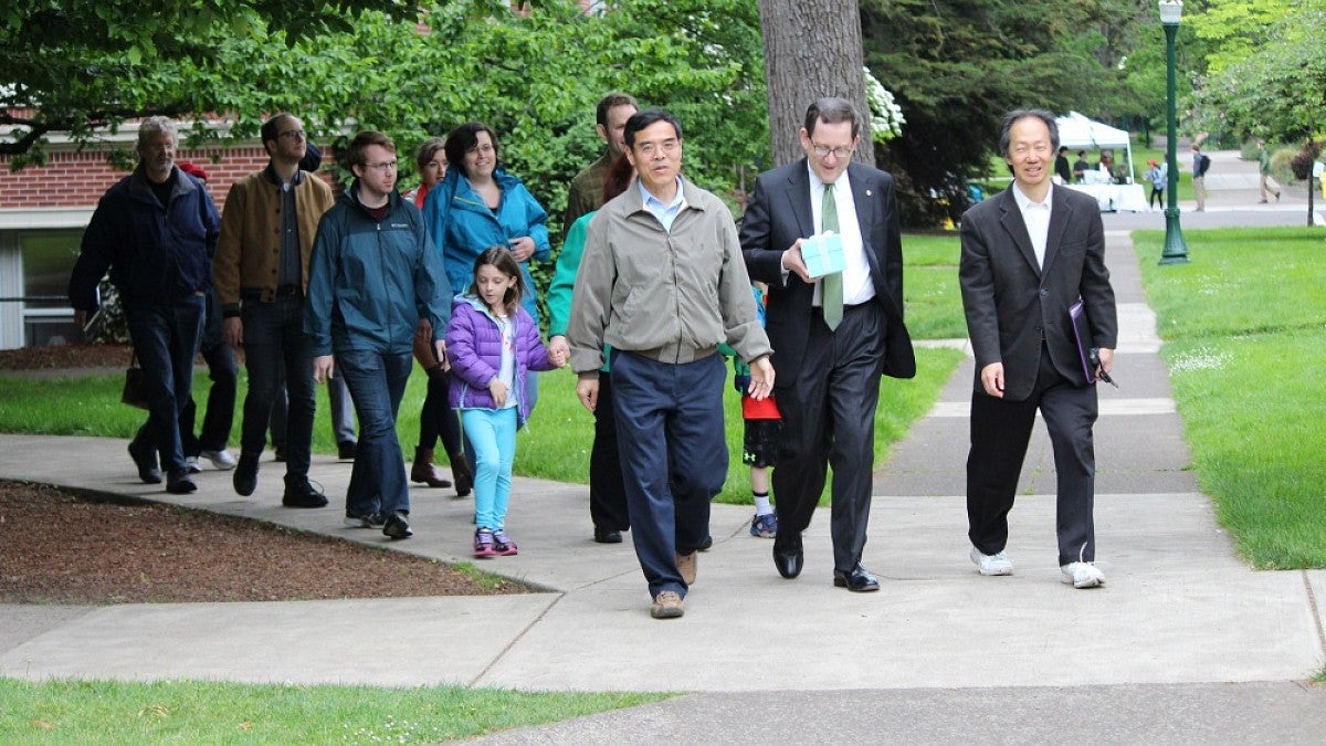 President Michael Schill and others walking across campus to deliver an award.