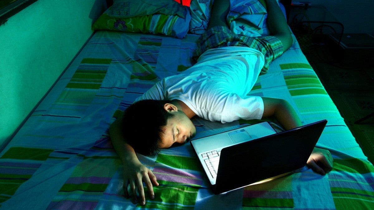 Teen asleep in front of laptop