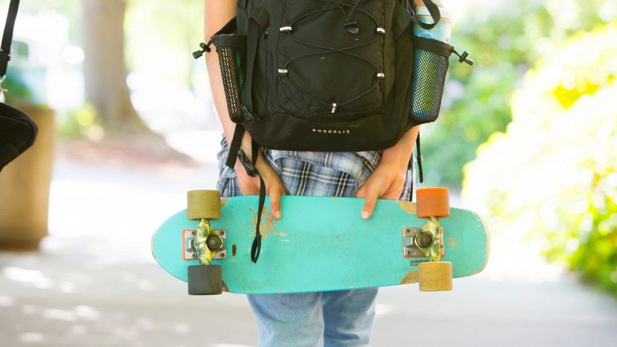 Student carrying skateboard