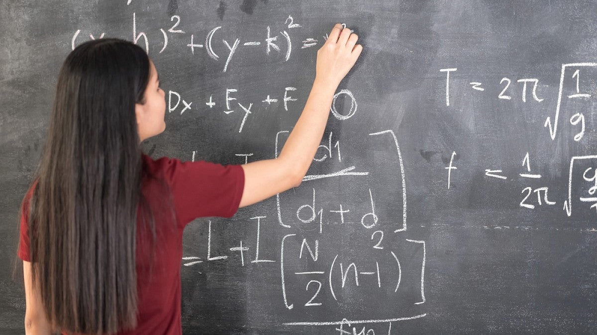 Woman doing math on blackboard
