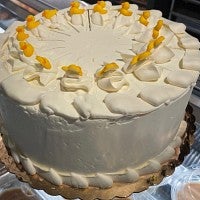 round white frosted cake with yellow ducks around top