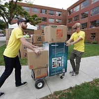 Volunteers use a trolley for a large load.