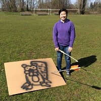 Josie Greer stands by the target she hit with her atlatl
