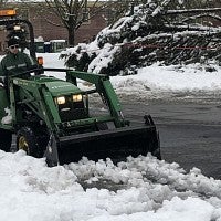 Front loader clearing snow
